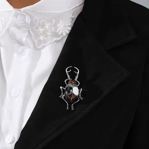 Vintage beetle insect brooch with amber and black enamel detail on a black blazer