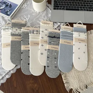 Collection of vintage-style floral and heart patterned socks in soft grey and cream tones.