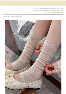 Detailed shot of beige mesh stirrup leg warmers with ballet flat shoes, stylish summer socks.