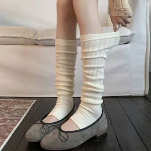 Cream ribbed knit leg warmers shown on legs with ballet flats for a stylish cozy look.