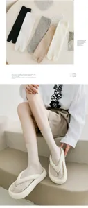 Detailed view of solid color split-toe cotton socks worn with stylish white flip-flop sandals