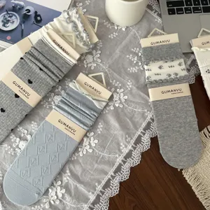 Detailed view of ruffled floral mid-tube socks in grey and blue tones