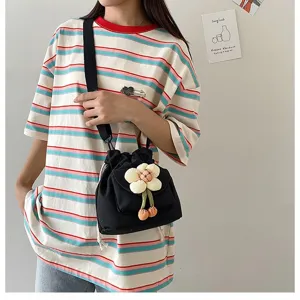 Detailansicht der schwarzen Leinenbeuteltasche mit süßem Blumenanhänger im Japan-Stil