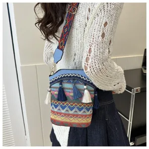 Vintage Ethno-Stil Eimertasche mit bunten Quasten, getragen von einem modischen Model