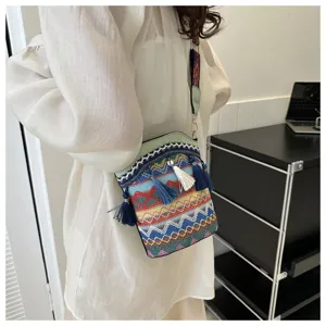 Detailaufnahme einer gewebten Bucket Bag im Ethno-Stil mit bunten Quasten und Riemen