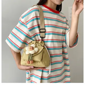 Süße japanische Canvas-Umhängetasche mit Blumendetail, getragen von einem Model.