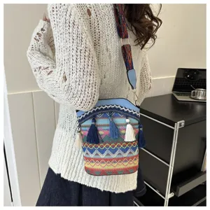 Detailansicht der gewebten Bohème-Beuteltasche mit bunten Quasten und Mustergurt