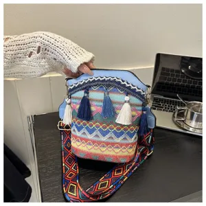 Detailansicht der bunten böhmischen Eimertasche mit Quasten und gewebtem Riemen