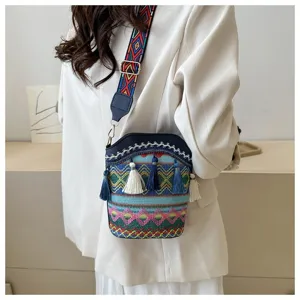 Detailansicht einer ethnischen Eimertasche mit bunten Quasten, von Model getragen