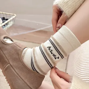 Detailed view of cream striped socks with plush trim and As You Wish embroidery detail