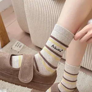 Detail shot of warm striped crew socks featuring elegant 'As You Wish' embroidery