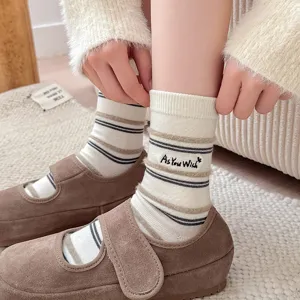 Close-up of cream striped socks with 'As You Wish' embroidery and brown Mary Janes