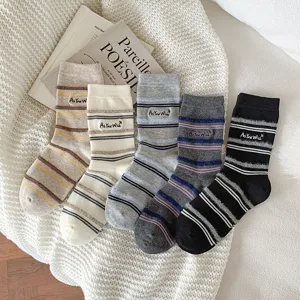 Macro detail of striped thermal autumn socks with an embroidered 'As You Wish' patch