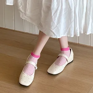 Close-up detail of cute pink hollow short socks paired with white studded Mary Jane flats.