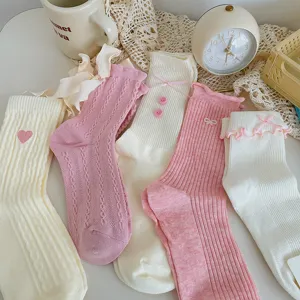 Detail view of cute Japanese style socks with bows, hearts, and ruffled lace edges.