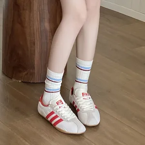 Gros plan de chaussettes mi-hautes en coton blanc pour femmes avec rayures rouges et bleues
