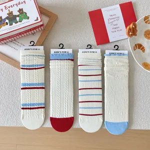 Vue détaillée de chaussettes en coton crème avec rayures rouges et bleues