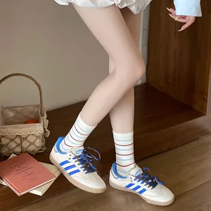 Gros plan de chaussettes mi-hautes en coton blanc avec rayures rouges et bleues pour femmes