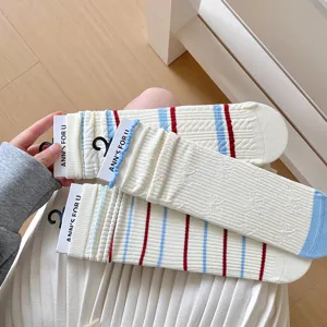 Détail de chaussettes mi-mollet en coton à rayures et côtes pour femmes, style collège