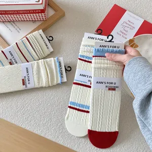 Détails rapprochés de chaussettes en coton avec rayures rouges bleues et bords à volants doux