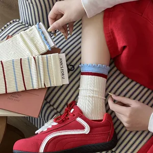 Détail de chaussettes en coton à rayures rouges et bleues avec bords à volants style preppy