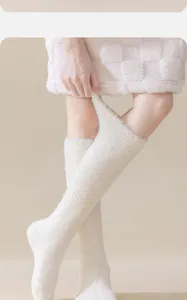 Close-up of soft white coral fleece knee-high socks for winter warmth and cozy home wear