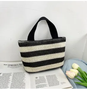Sac à main chic en paille tressée à rayures noires et crème sur fond minimaliste
