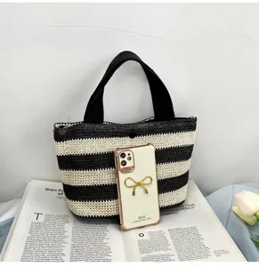 Vue détaillée de la texture tissée de ce sac à main en paille à rayures noires et blanches.