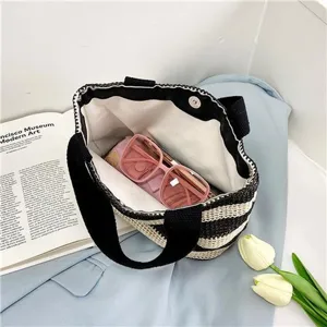 Vue de dessus détaillée d'un sac tissé rayé montrant l'intérieur avec lunettes roses