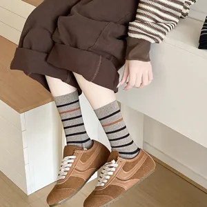 Close-up of stylish Korean striped crew socks in earth tones with ribbed texture
