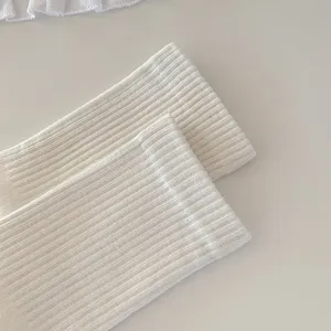 Macro view of the white ribbed knit texture on these soft cotton five-toe mid-calf socks.