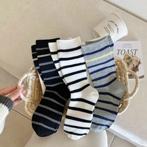 Close-up view of three pairs of Korean style striped crew socks for women in a basket