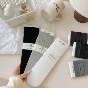 Detailed view of ribbed mid-calf women socks in multiple colors with paper band packaging.
