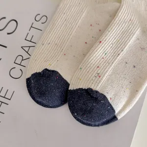 Nahaufnahme von japanischen Damen-Mittelsocken mit buntem Noppengarn und kontrastierender Ferse.