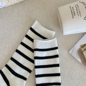 Close-up of black and white striped mid-calf socks with ribbed knit texture detail