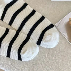 Close-up of black and white striped knit mid-calf socks with ribbed texture.