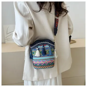 Detailansicht der Ethno-Beuteltasche mit Boho-Stickerei und Quasten an einem Modell
