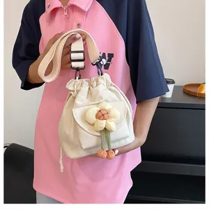Detailaufnahme einer süßen japanischen Canvas-Umhängetasche mit Plüschblumen-Anhänger