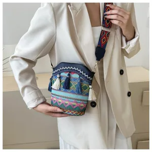 Detailansicht der Ethno-Eimertasche mit bunten Quasten und gemustertem Riemen