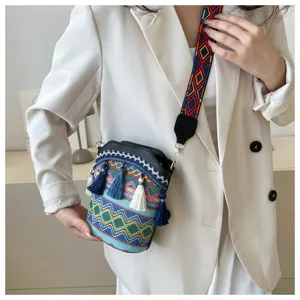 Nahaufnahme einer ethnischen Eimertasche mit bunten Quasten, getragen von einem Modell