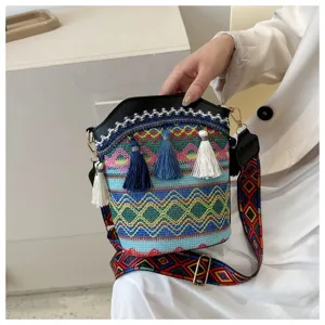 Detailansicht einer Ethno-Beuteltasche mit bunten Webmustern und Quastenverzierung.