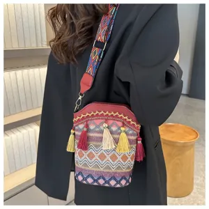 Detailansicht der Ethno-Eimer-Tasche mit bunten Quasten und Stickerei-Schultergurt