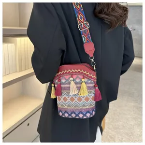 Nahaufnahme der von einem Model getragenen Ethno-Eimertasche mit bunten Riemen
