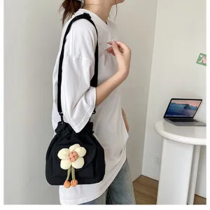 Detailansicht einer süßen Leinwand-Umhängetasche mit Blume am Modell