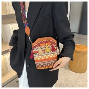 Detailansicht einer gewebten Eimertasche im Ethno-Stil mit Quasten an einem Blazer