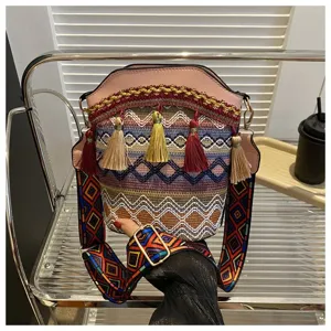 Nahaufnahme einer Eimer-Tasche im Ethno-Stil mit bunten Quasten und Riemen.