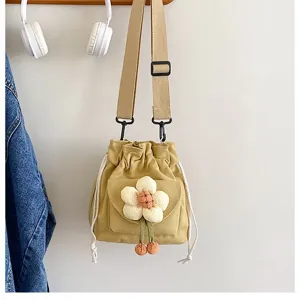 Detailansicht einer süßen gelben Canvas-Umhängetasche mit weicher 3D-Plüschblume