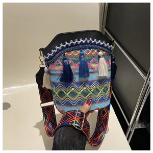 Detailansicht der lebendigen ethnischen Muster und Quasten an einer gewebten Beuteltasche.