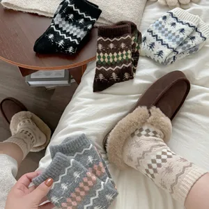 Detalle de calcetines de invierno de lana gruesa con patrón nórdico y pantuflas de felpa.