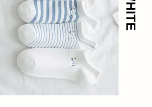 Detail van schattig schapenborduursel op blauw-wit gestreepte katoenen enkelsokken